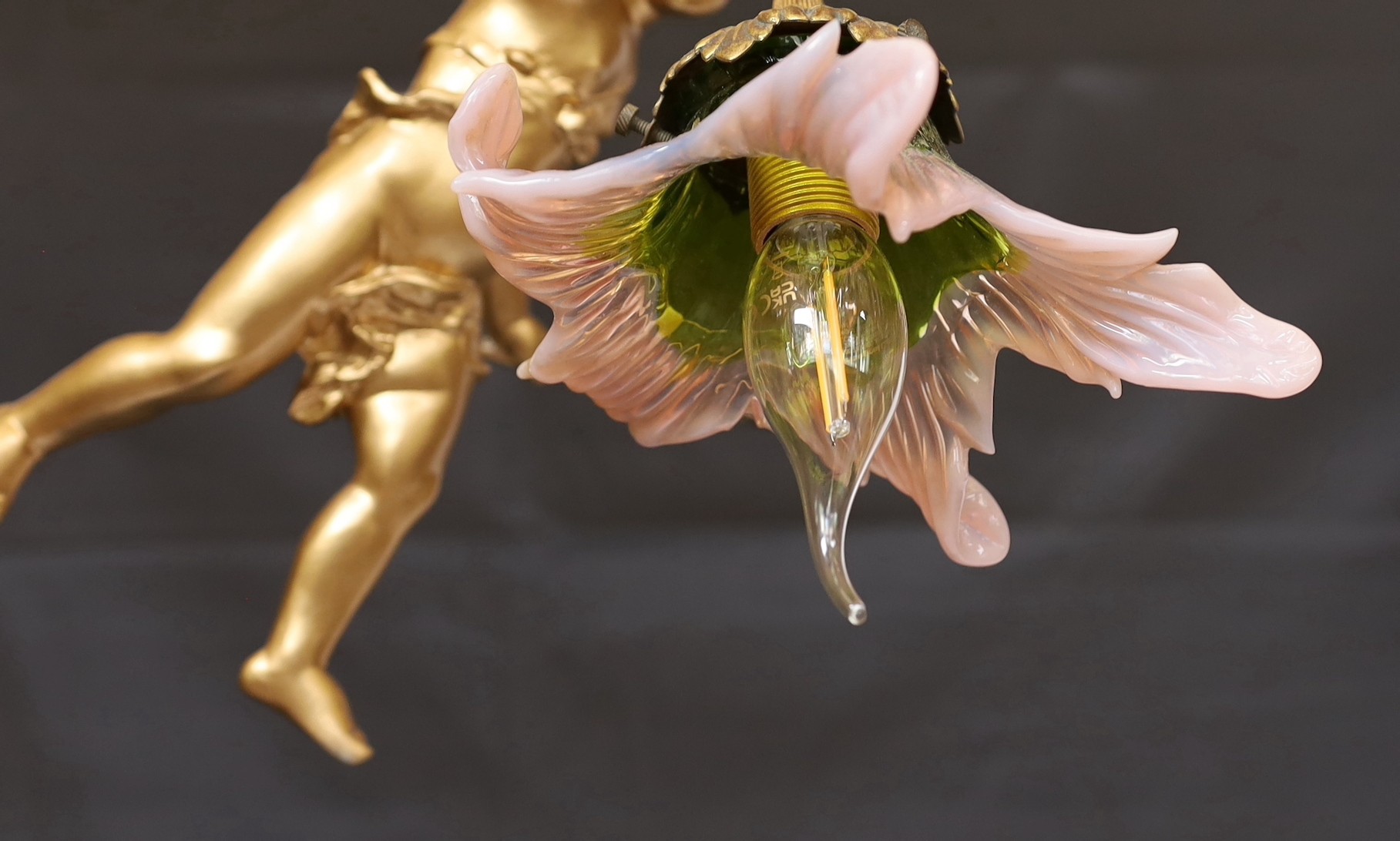 A 1920s English gold painted spelter Cupid light fitting with coloured glass shade, height 54cm. width 24cm